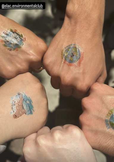 Five fists with colorful temporary tattoos, each featuring different designs.